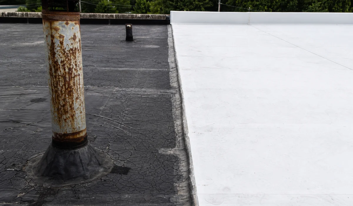 Aging flat roof next to newly installed membrane
