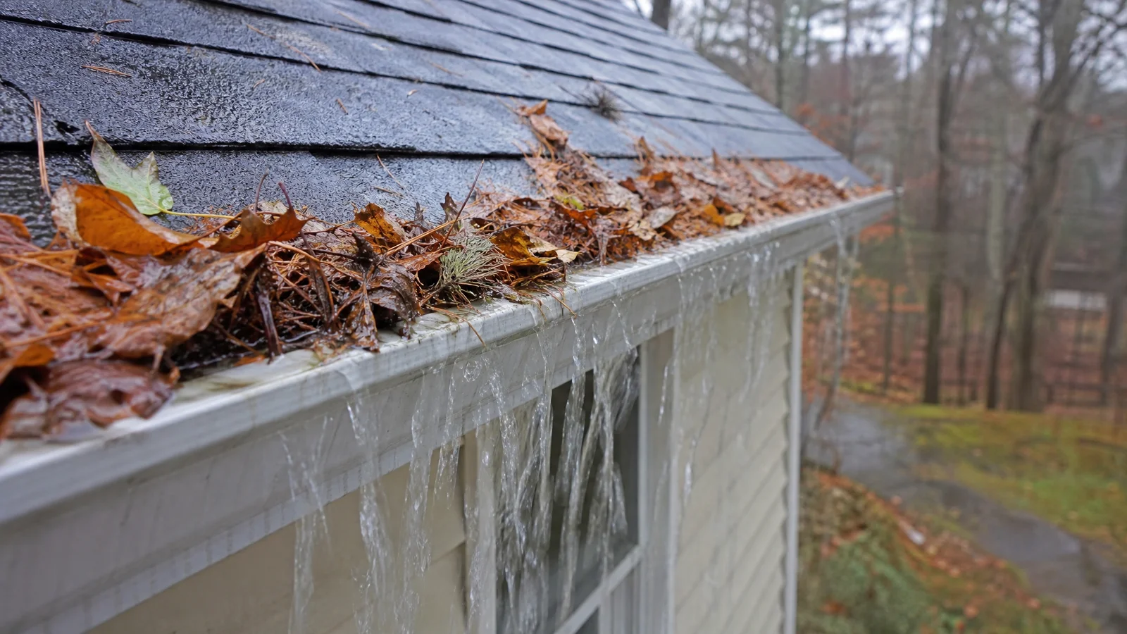 Overflowing clogged gutter during rain